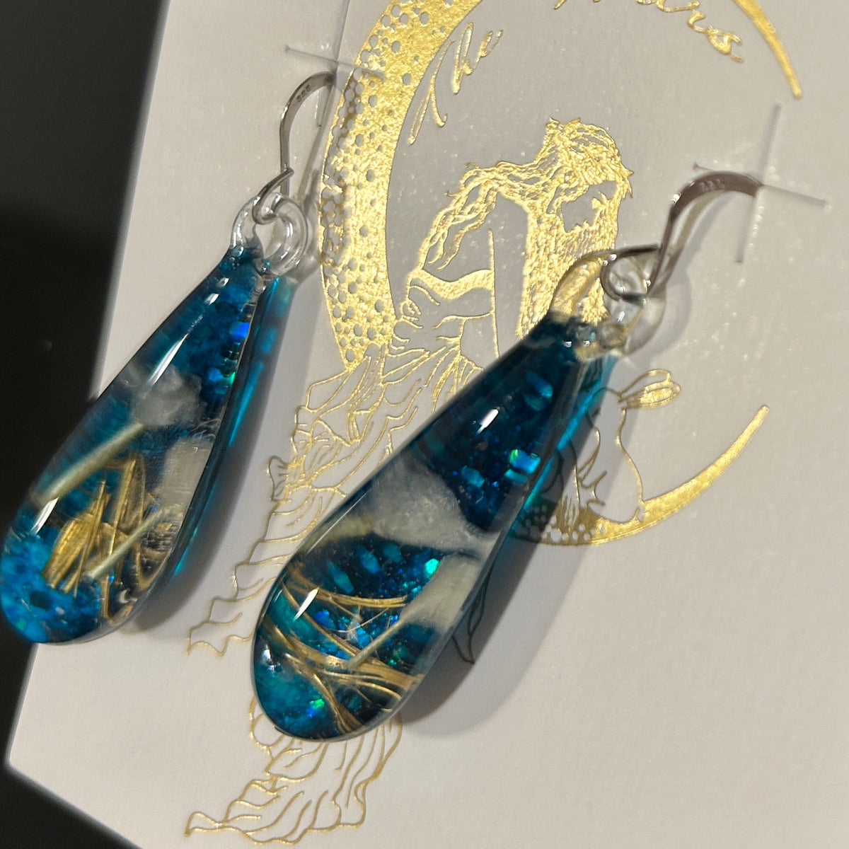 Handmade botanical dichroic glass drop earrings 2.1 inches long with real dried grass straws suspended in blue glass on sterling silver ear wires