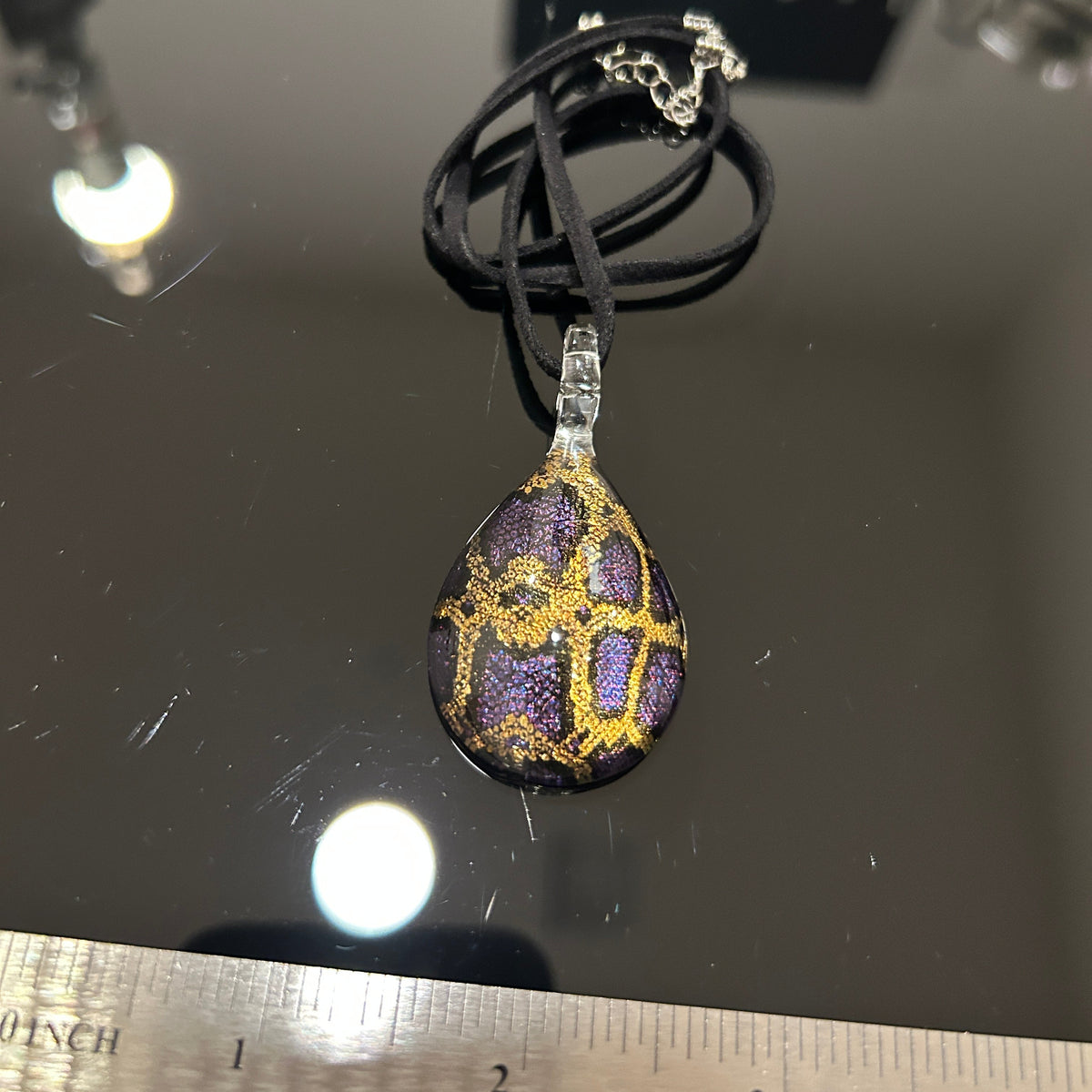 Handmade tree of life pendant in dichroic glass. 2 inches long, 1.25 inches wide. Blue and gold geometric design. Solid glass construction. 21" cloth cord included.